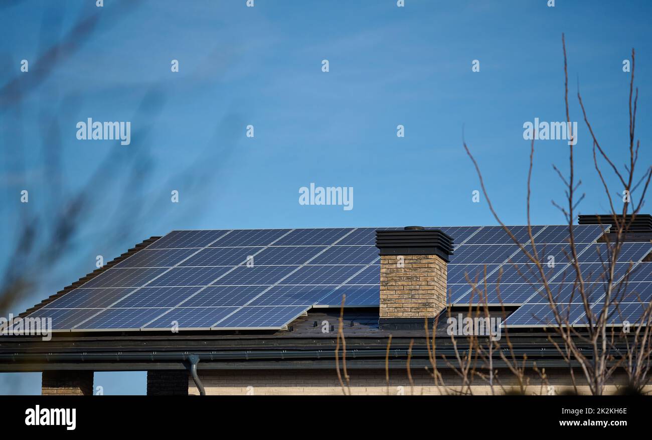 Dach eines Wohngebäudes mit Solarzellen. Konzept für grüne Energie und Energieunabhängigkeit Stockfoto