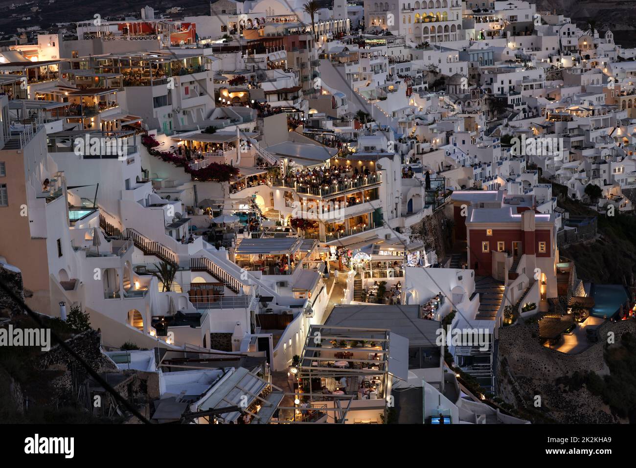 Beleuchtete Balkonterrassen und Terrassen mit Restaurants der Stadt Fira auf Santorini Insel. Stockfoto