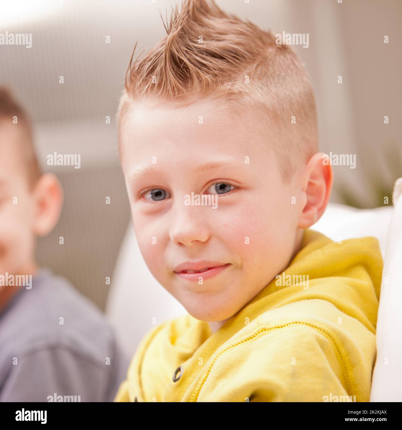 Ein kleiner Junge, der mit seinem Freund vor der Kamera lächelt Stockfoto