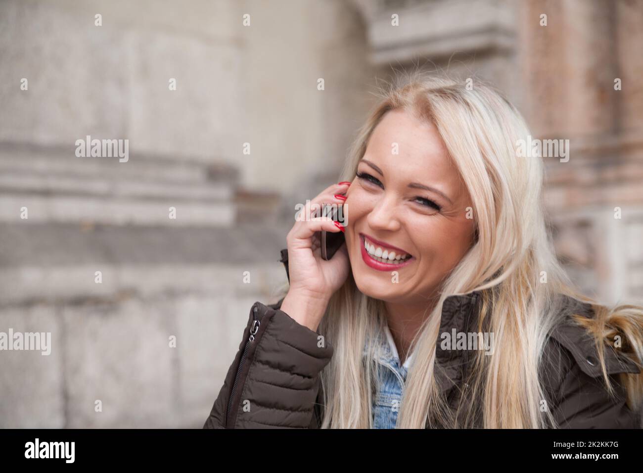 Blonde Touristen, die aus Europa nach Hause telefonieren Stockfoto