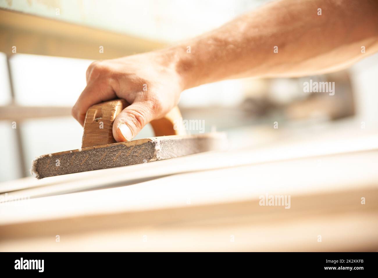 Person, die die Holzbohle vollständig glatt schleift Stockfoto