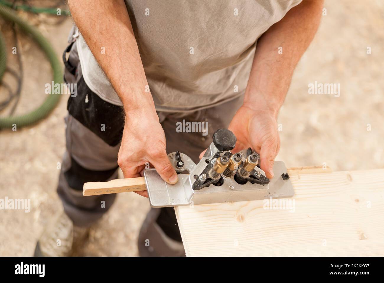 Holzarbeiter, der eine Lehre auf einem Holzbrett hält Stockfoto