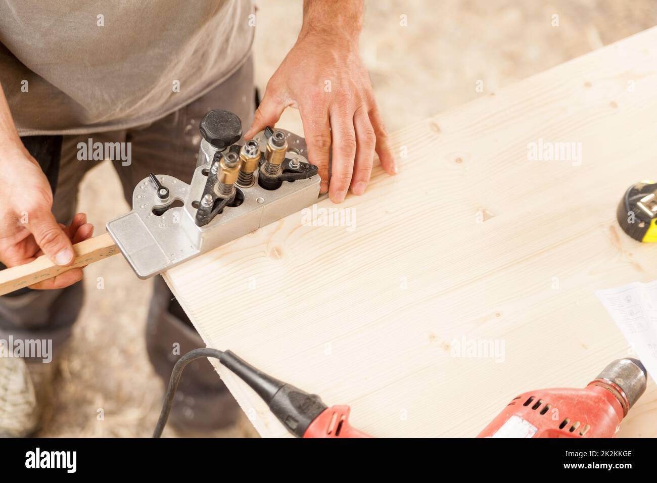 Holzarbeiter, der eine Lehre auf einem Holzbrett hält Stockfoto