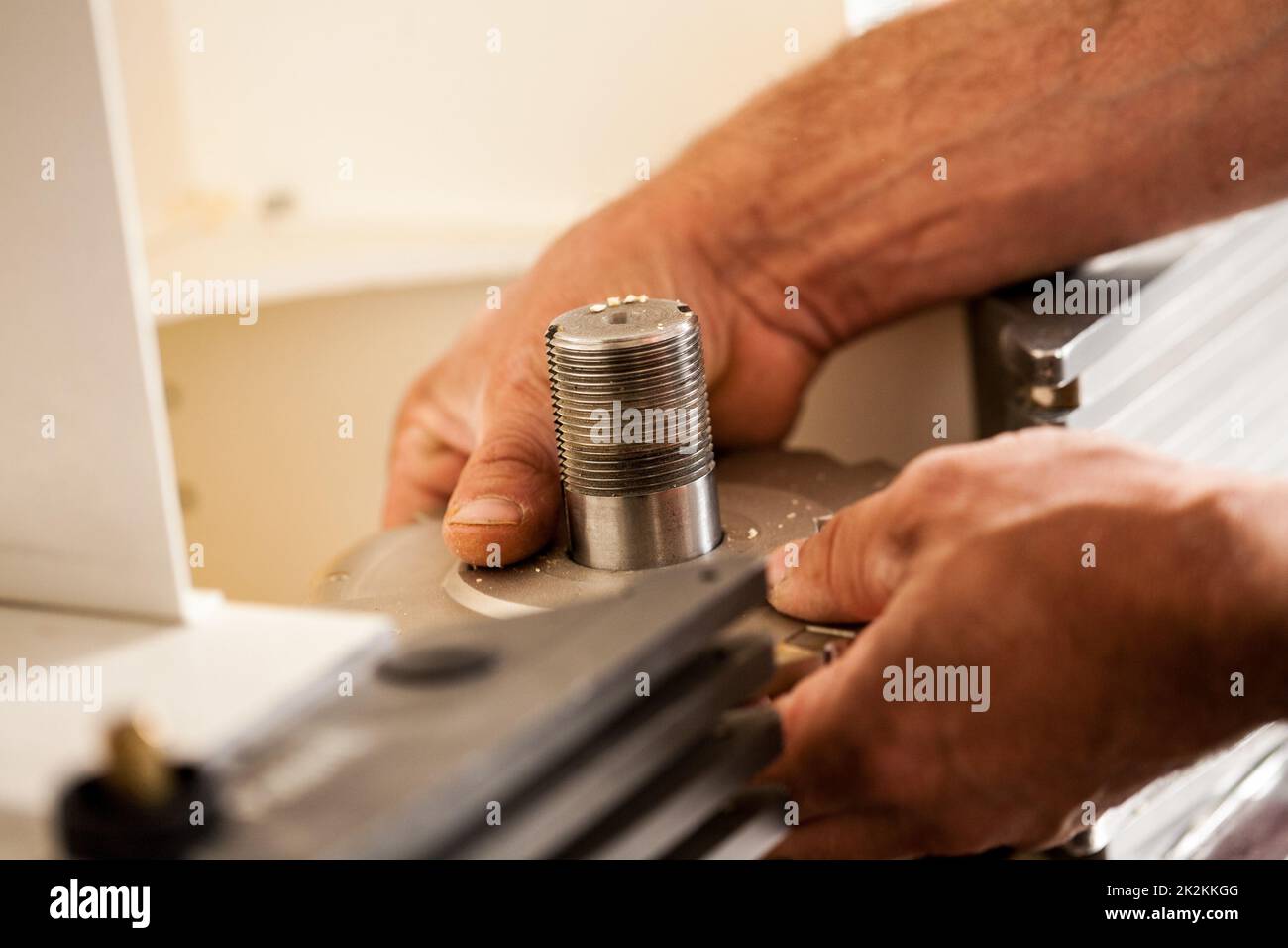 Die Hand eines Holzarbeiters, der einen Fräser aufstellt Stockfoto