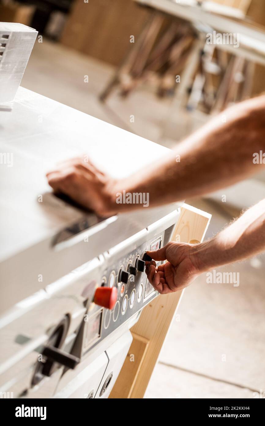 Ein- und Ausschalten einer Maschine in einer Holzarbeiter-Werkstatt Stockfoto