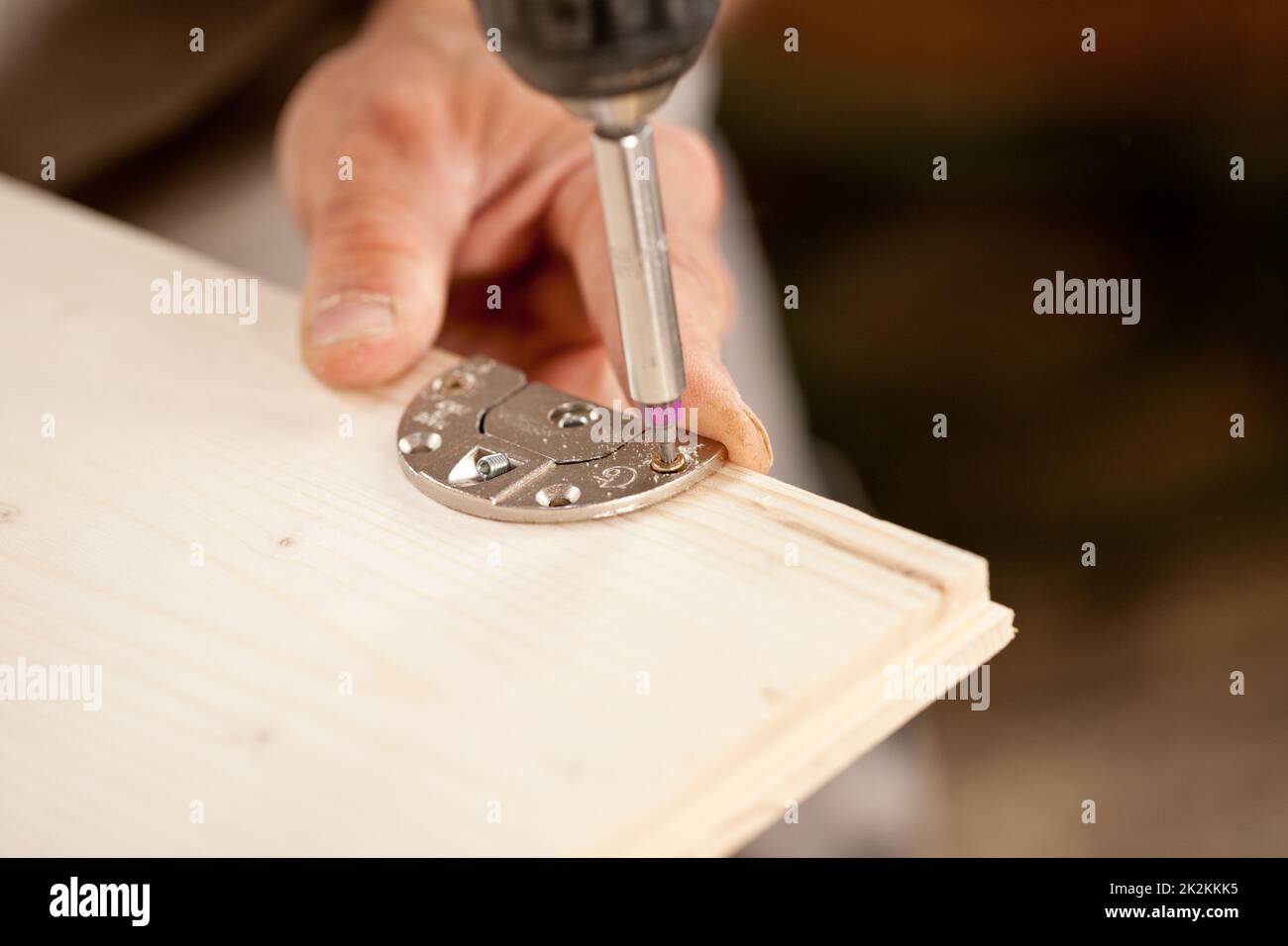 Konzentrieren Sie sich auf einen Schraubendreherbit, der eine Holzplatte verschraubt Stockfoto