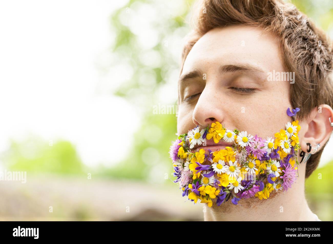 Porträt eines Mannes mit Blumen anstelle seines Barts Stockfoto