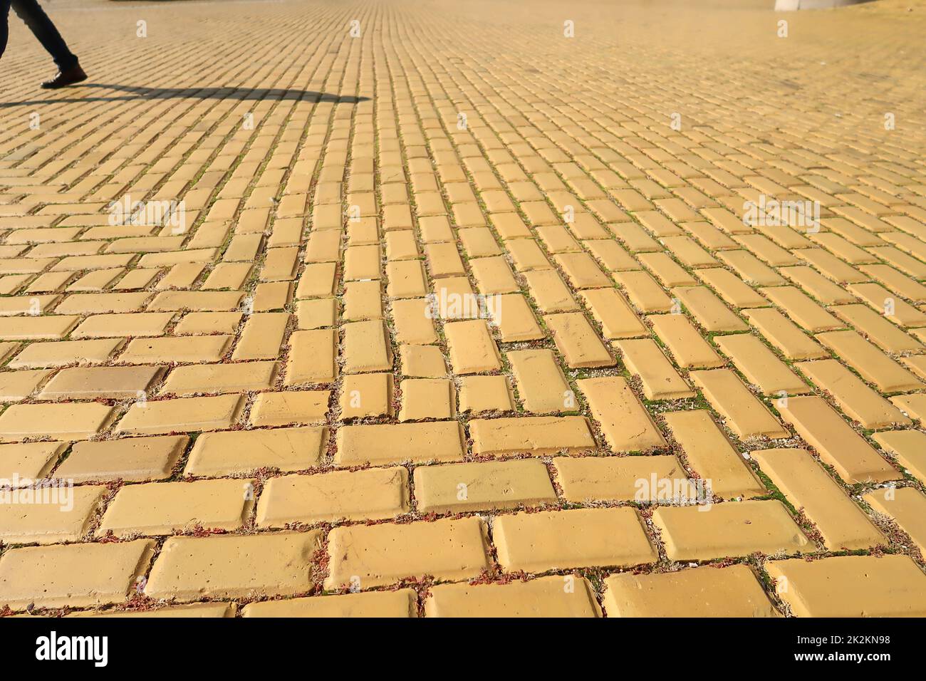 Gelbes Kopfsteinpflaster, Ziegelstraße in Sofia, Schatten von Fußgänger im Hintergrund Stockfoto