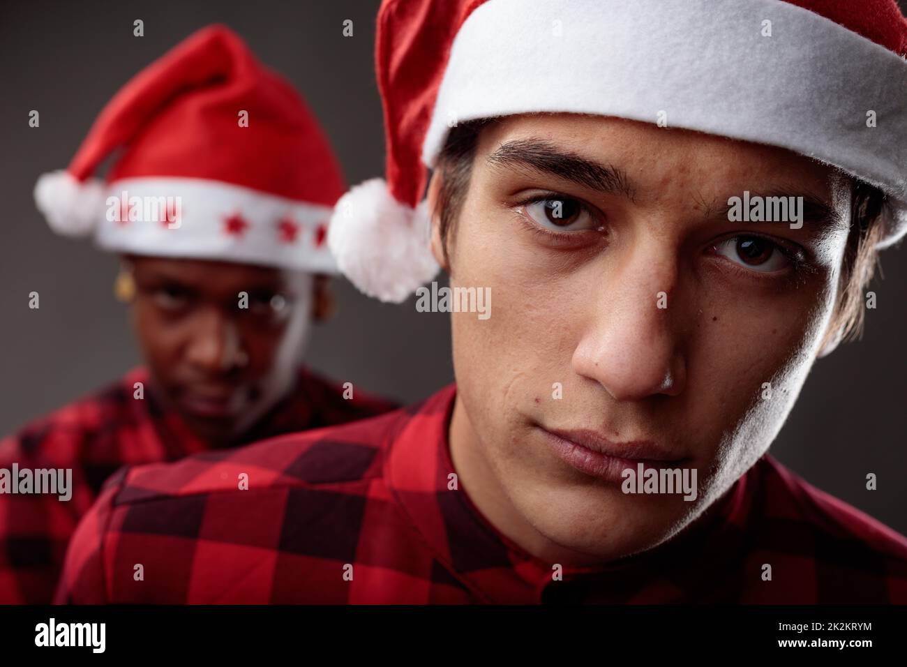 Weihnachtsporträt von zwei jungen Männern in Weihnachtsmannhüten Stockfoto