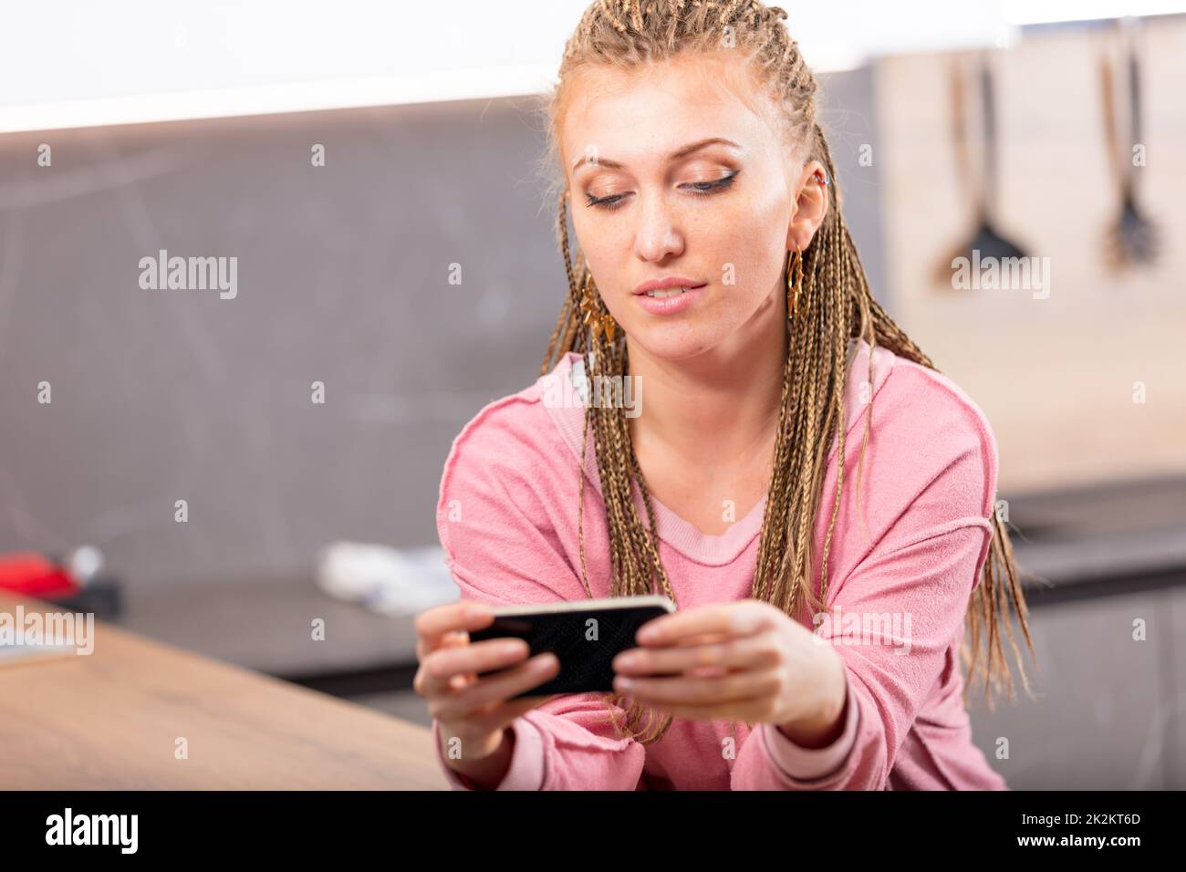 Attraktive junge Frau, die eine SMS-Nachricht lesen Stockfoto