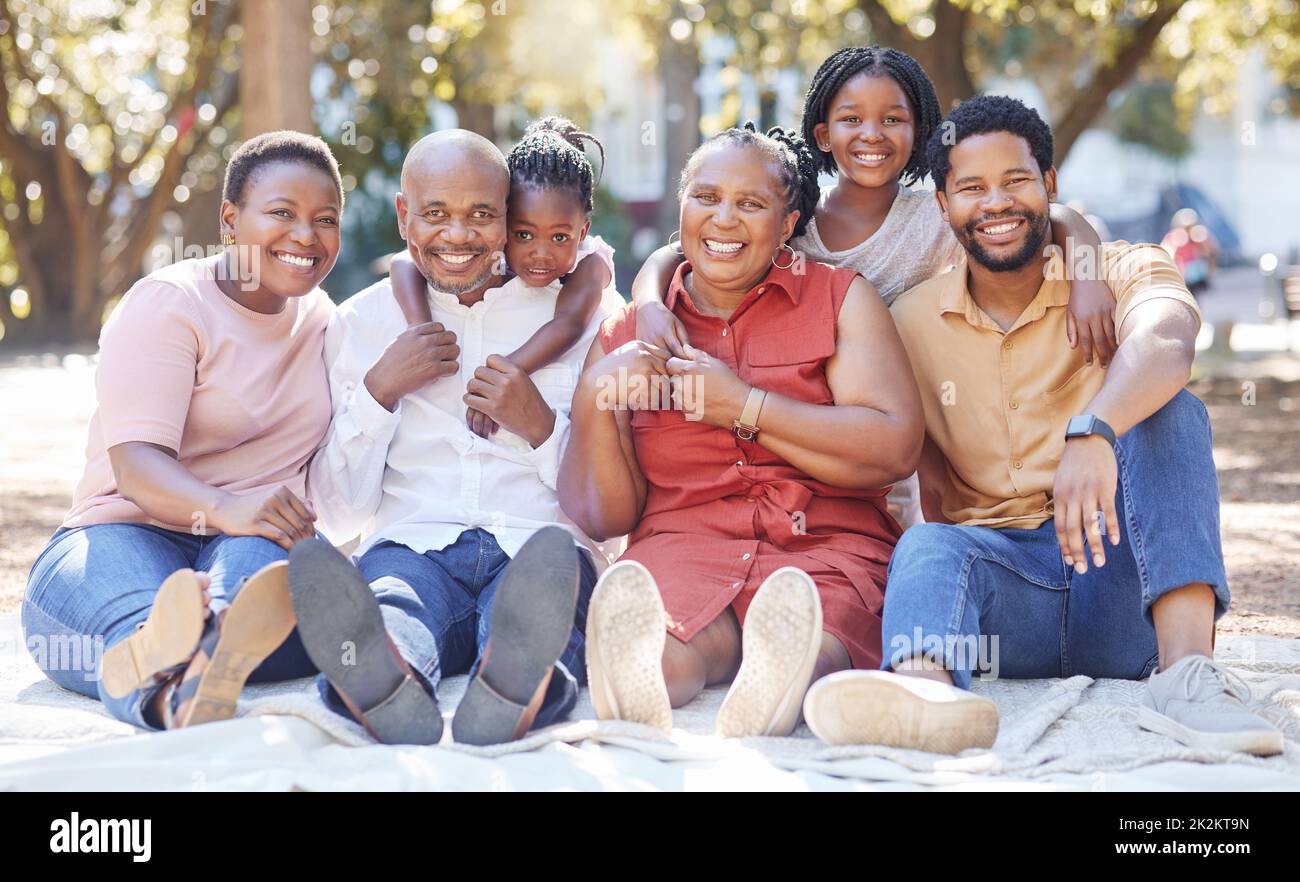 Großes Familienportrait, schwarze Menschen und Kinder, Großeltern im Outdoor-Park, Picknick oder treffen sich. Umarmung und Liebe zu afrikanischer Mutter, Vater und Kindern Stockfoto