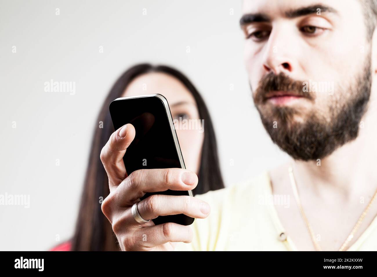 Frau enttäuscht über seinen Mann auf seinem Handy Stockfoto