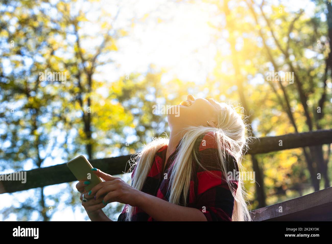 Eine lachende Frau, die vom warmen Sonnenschein beleuchtet wird Stockfoto