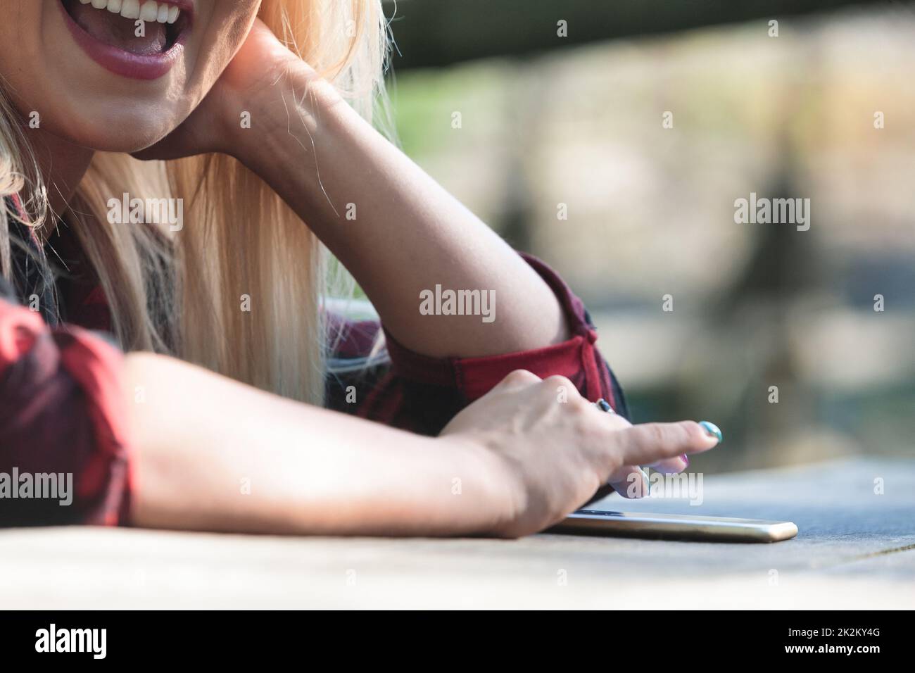 Nahaufnahme eines freigestellten Porträts einer jungen Frau, die draußen sitzt Stockfoto