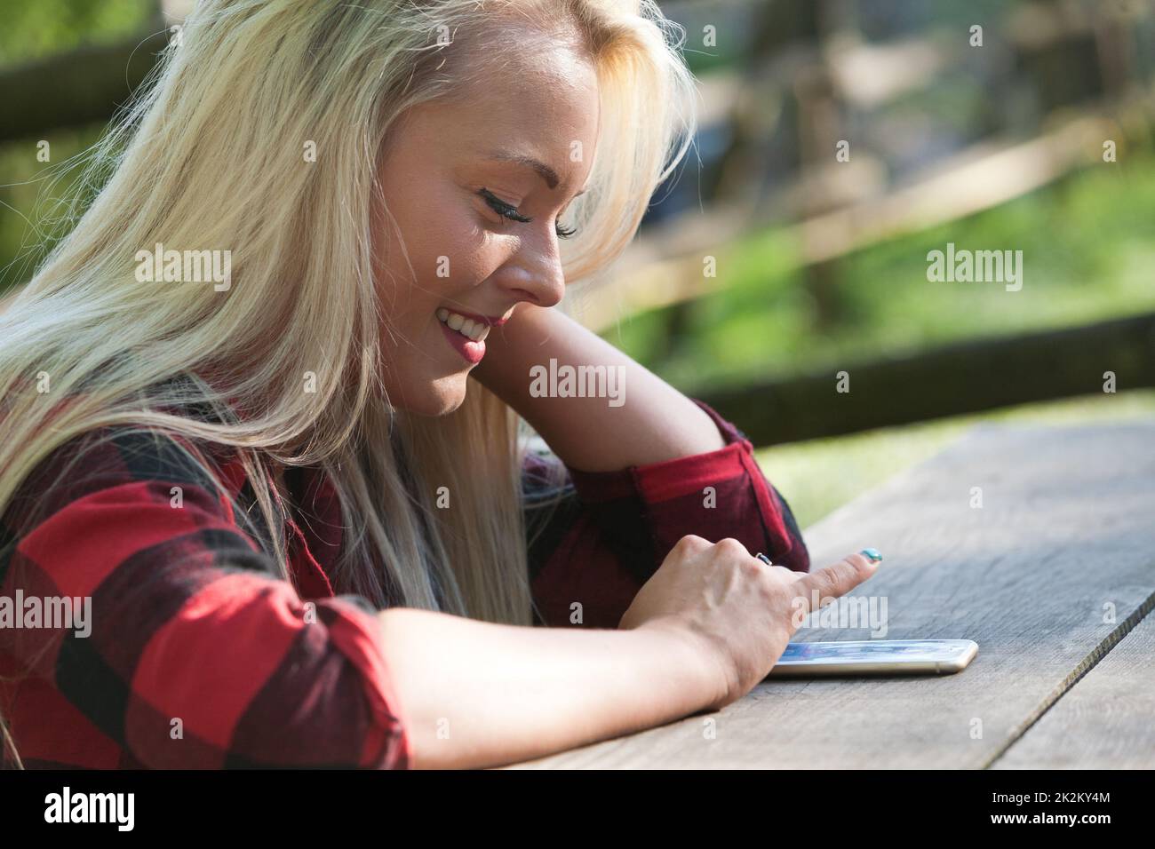 Ein Mädchen im Park mit einem Telefon Stockfoto