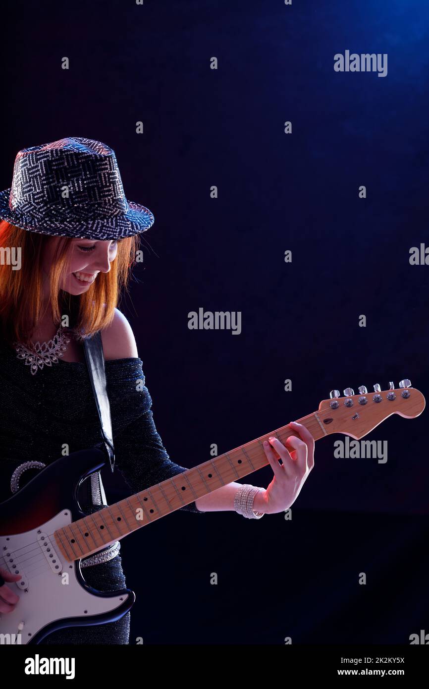 Hipster, trendige, junge Musikerin, die Gitarre spielt Stockfoto