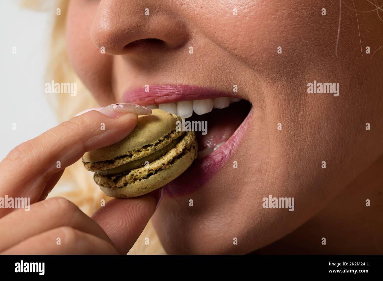 Nahaufnahme einer Makkarone, die vom Mund der Frau gefressen wird Stockfoto