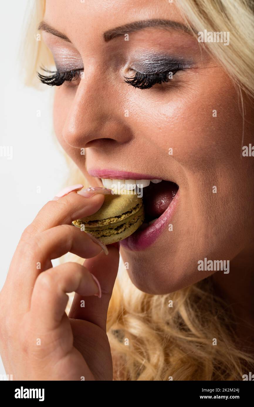 Eine Frau, die Makkaron isst und sich in sie verliebt Stockfoto