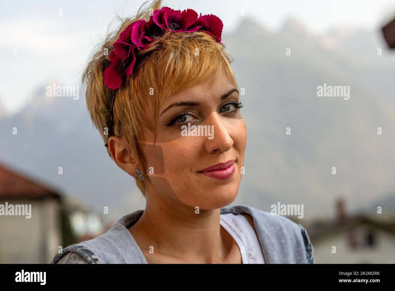 Junge Frau mit einer OP-Maske, braune Linien im Gesicht Stockfoto