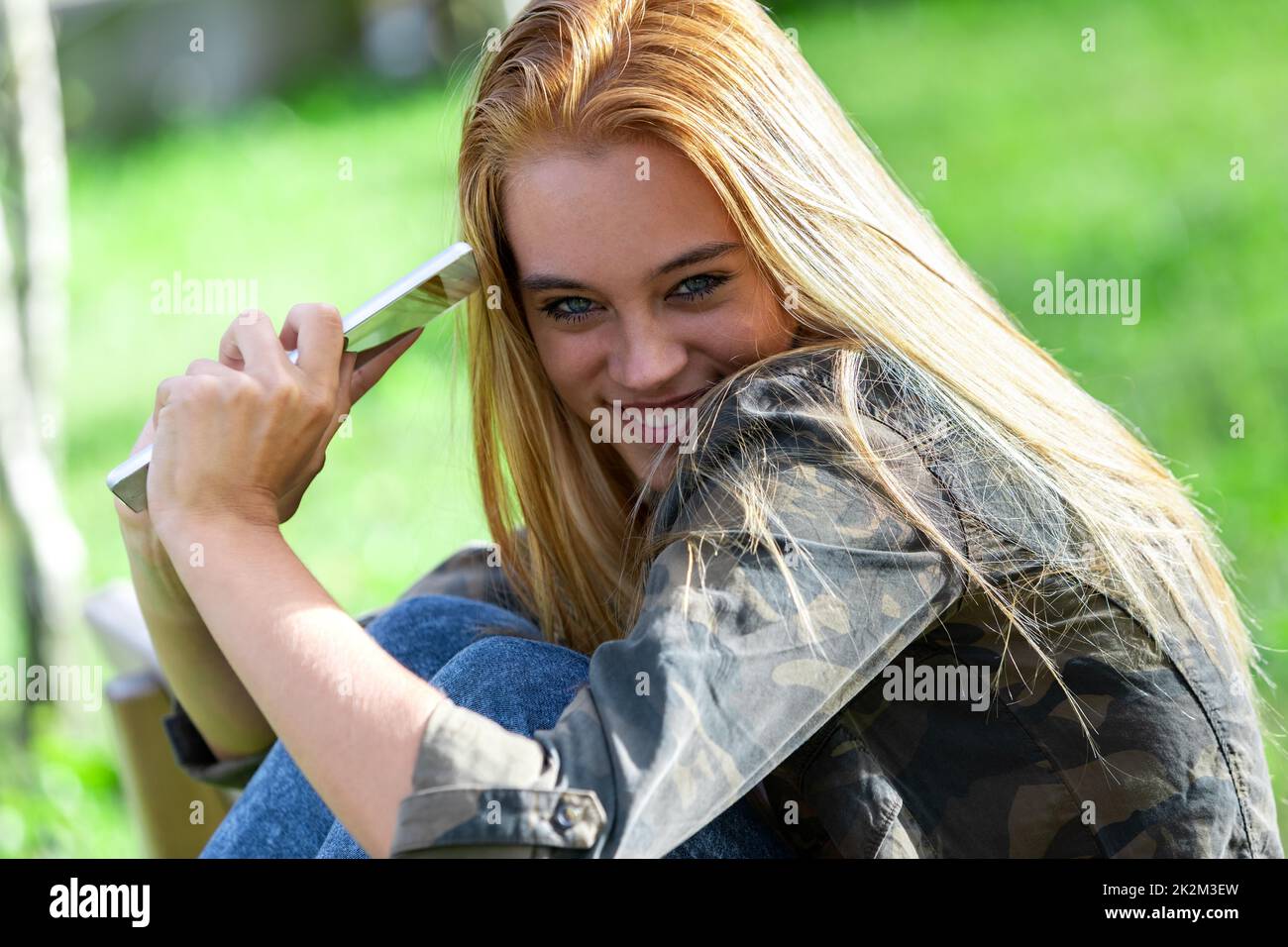 Lustige, schüchterne junge Frau, die in die Kamera grinst Stockfoto