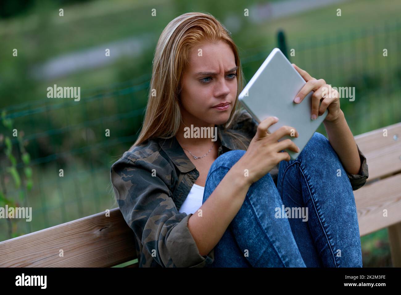 Verblüffte junge Frau, die auf einen Tablet-pc starrt Stockfoto