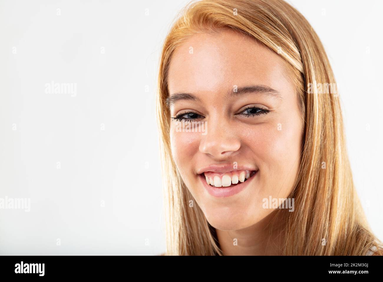 Glückliche lächelnde junge Frau, isoliert auf Weiß Stockfoto