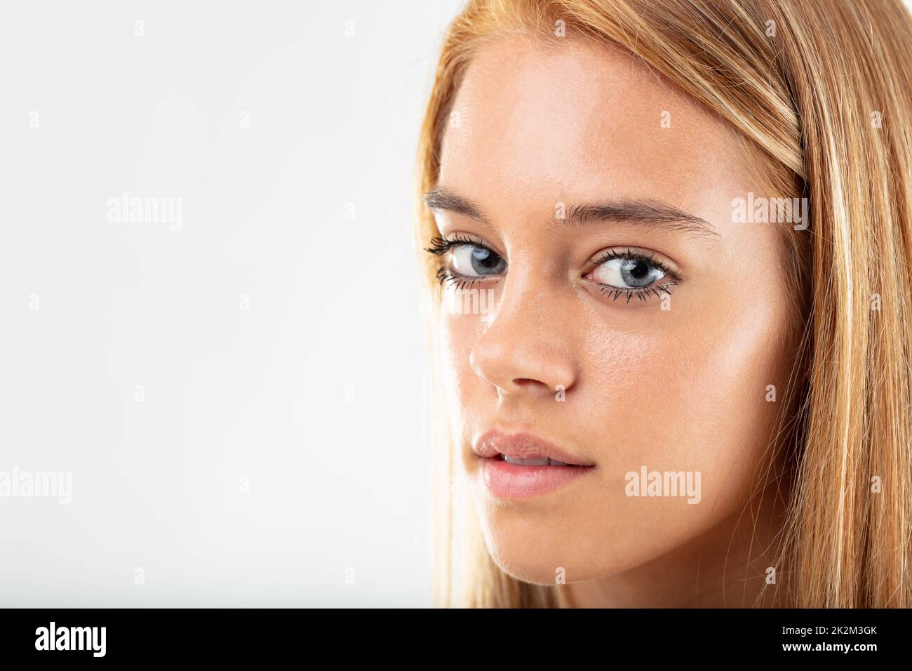 Eine fürsorgliche, hübsche junge Frau, die sich vor die Kamera stellt Stockfoto