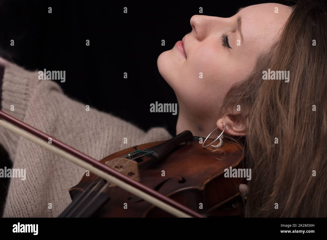 Leidenschaftlicher Geigenmusiker, der auf schwarzem Hintergrund spielt Stockfoto