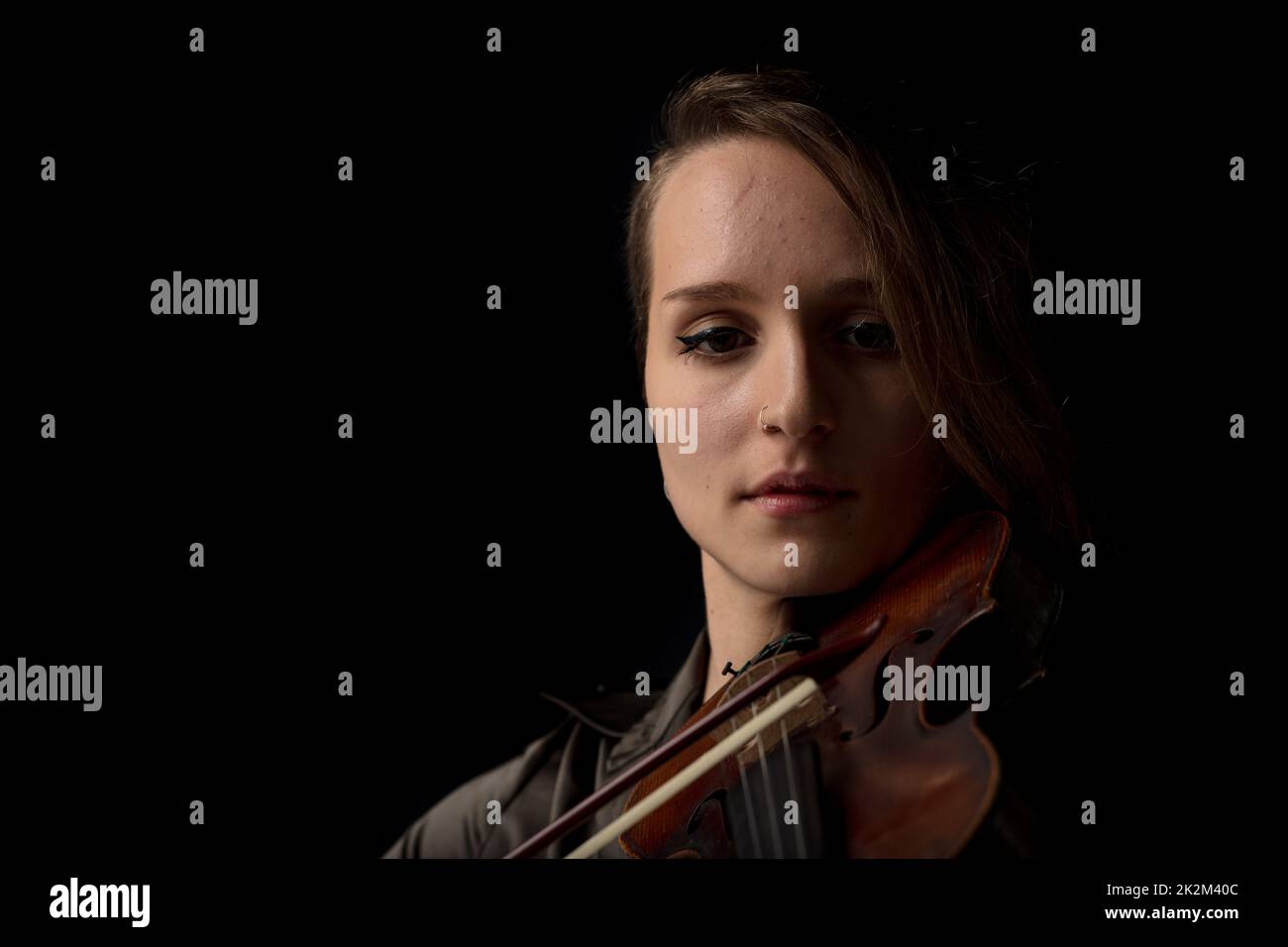 Schattiges Porträt einer Frau, die Geige spielt Stockfoto