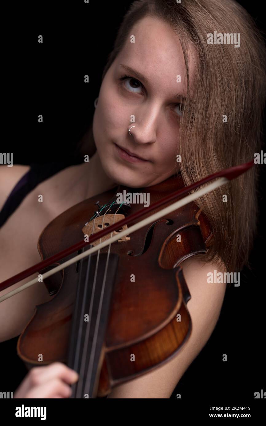Leidenschaftlicher Geigenmusiker, der auf schwarzem Hintergrund spielt Stockfoto