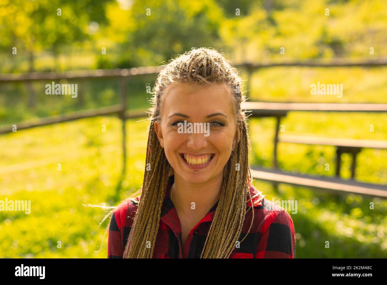 Lächelnde Frau in geflochtener Frisur im Freien Stockfoto