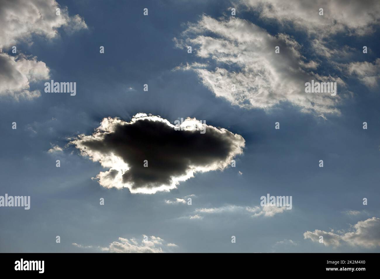 Schwarze Wolke bildet sich am blauen Himmel, dunkle Wolke bildet sich in verschiedenen und interessanten Formen Stockfoto