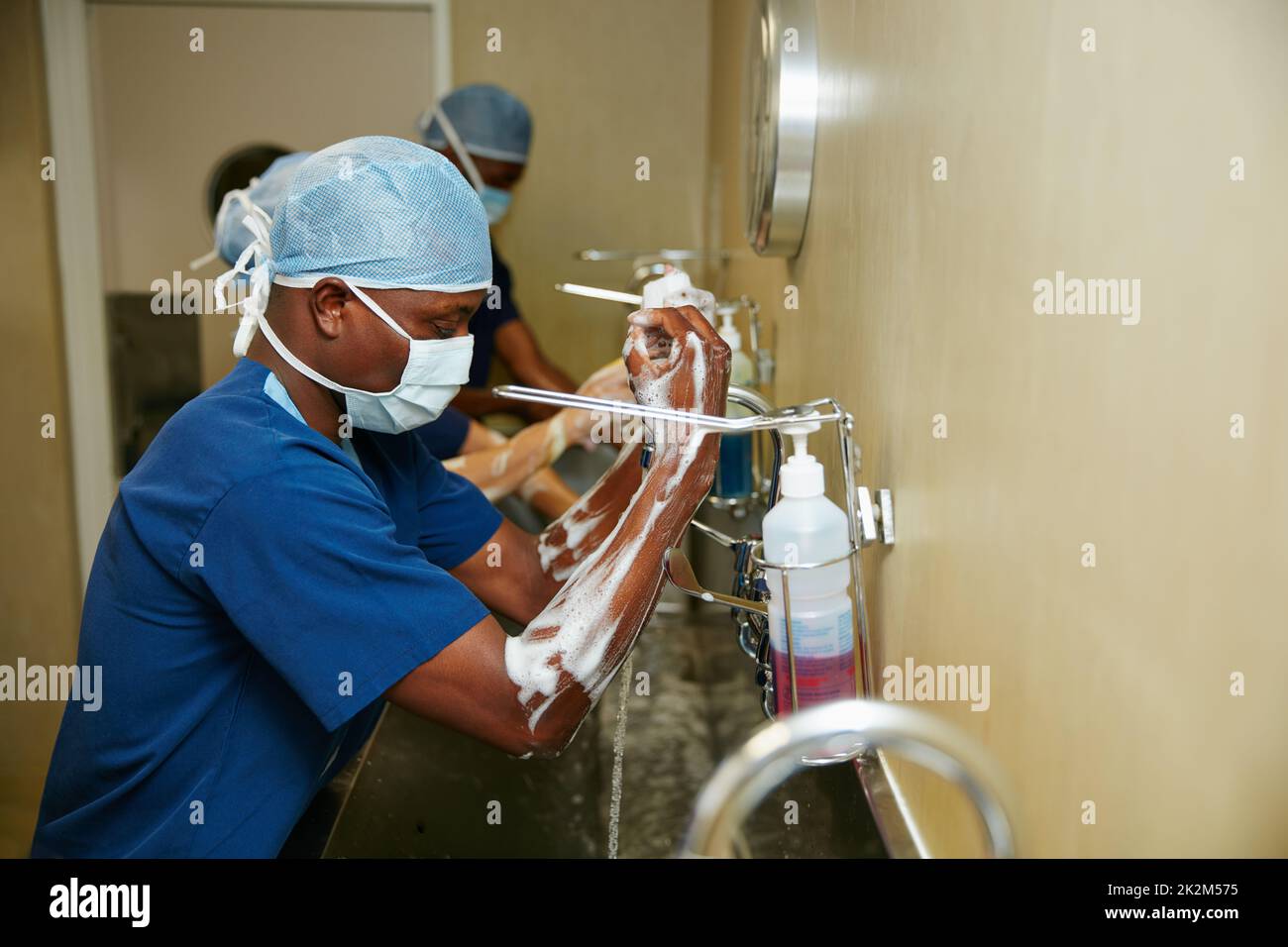 Hygiene ist von größter Bedeutung. Aufnahme eines Teams von Chirurgen, die ihre Arme und Hände im Rahmen eines chirurgischen Eingriffs sterilisieren. Stockfoto