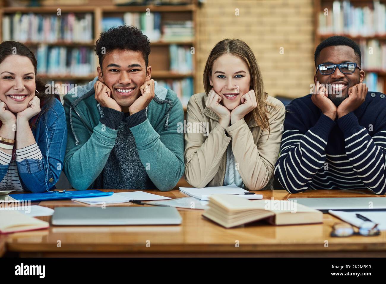 Bildung ist das Tor zu größeren Dingen. Porträt einer Gruppe von Studenten, die in der Bibliothek auf dem Campus sitzen. Stockfoto