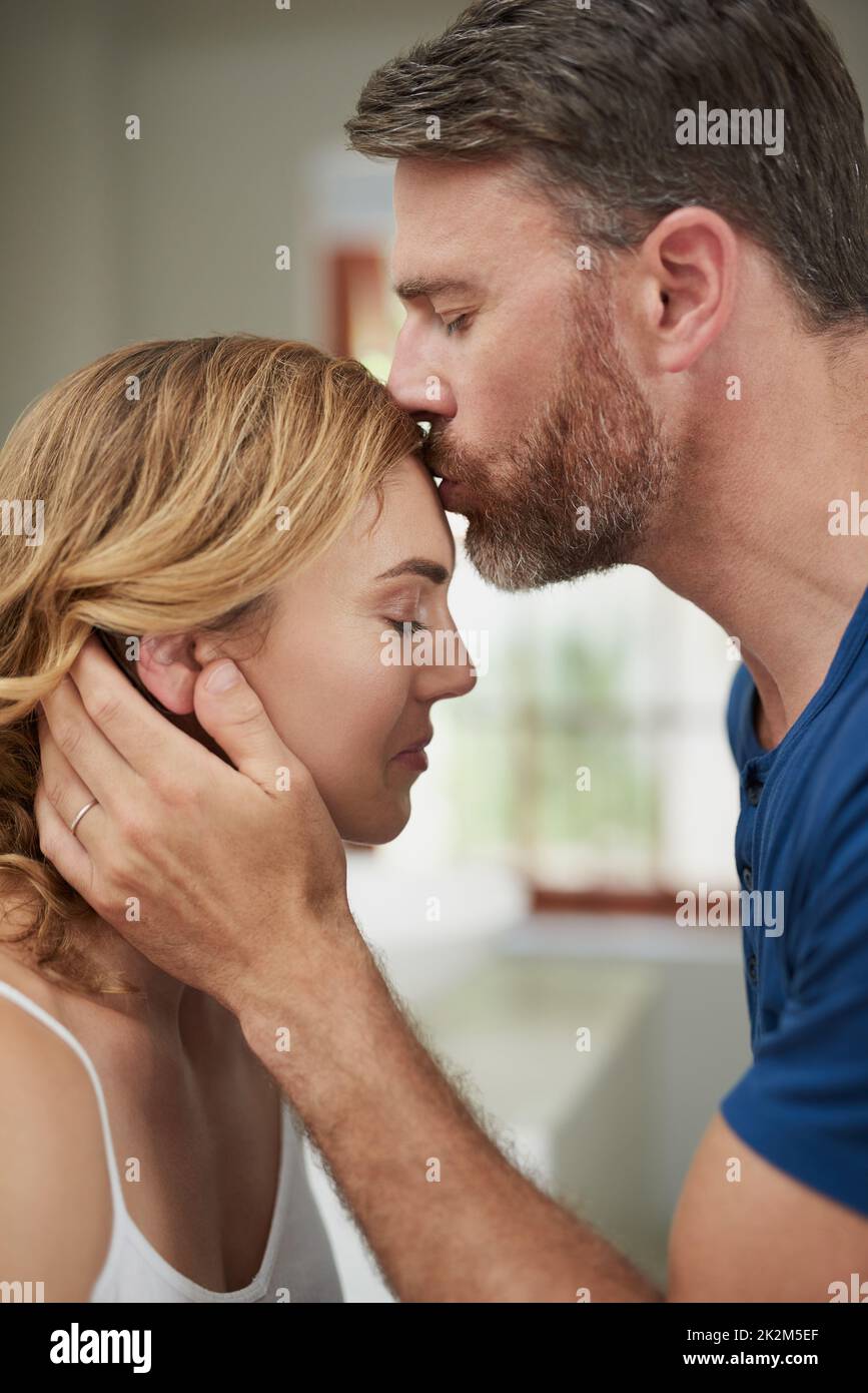 Das schönste Gefühl der Welt. Aufnahme eines glücklichen Paares mittleren Alters, das einen liebevollen Moment zu Hause teilt. Stockfoto