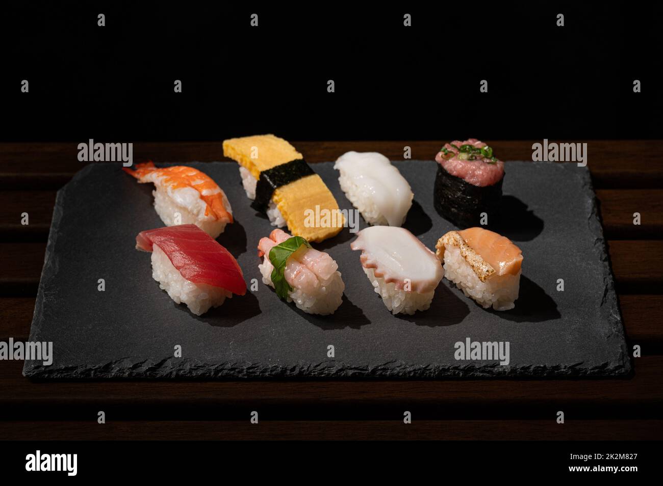 japanisches Sushi (Thunfisch, Ei, Garnelen, Kaviar, Lachs, Oktopus, Tintenfisch) auf dem Teller mit minimalem Stil Stockfoto