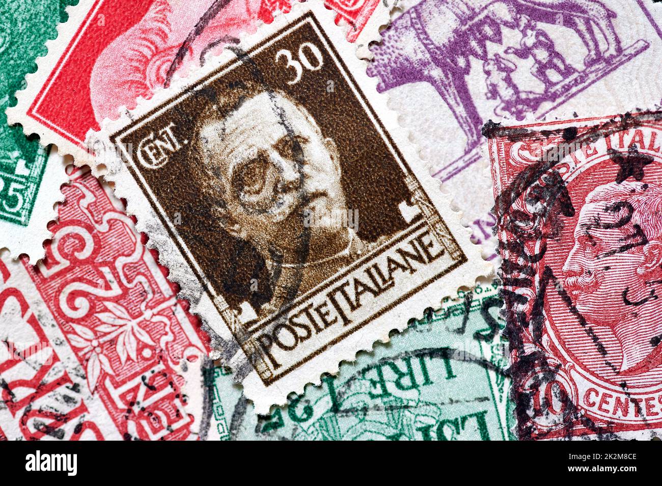 Briefmarke aus Italien, mit einem Porträt von König Viktor Emanuel III, der die Errichtung des Faschismus in Italien unterstützt, bildet einen Hintergrund zusammen Stockfoto