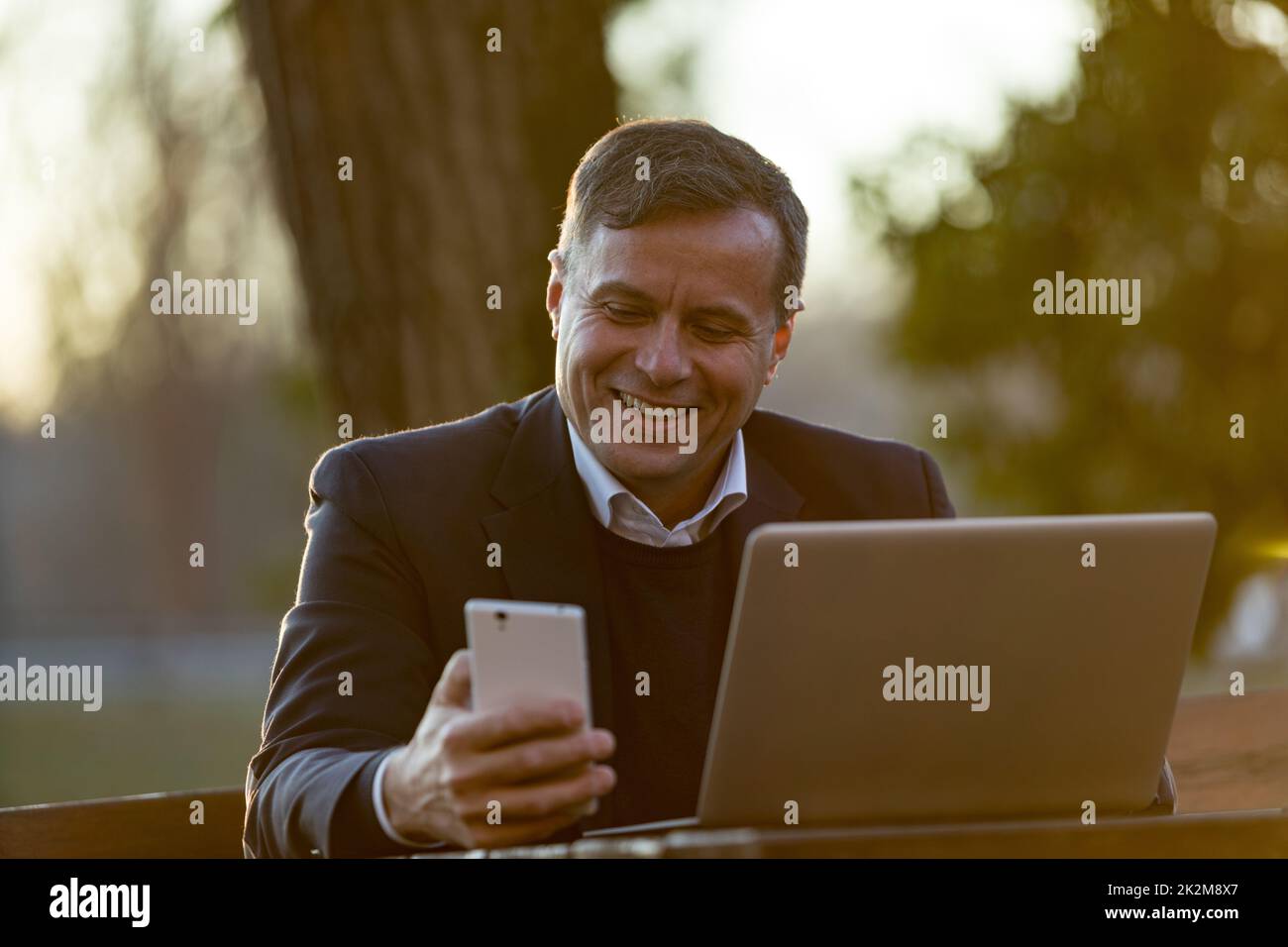 Glücklicher Geschäftsmann, der eine SMS erhält Stockfoto