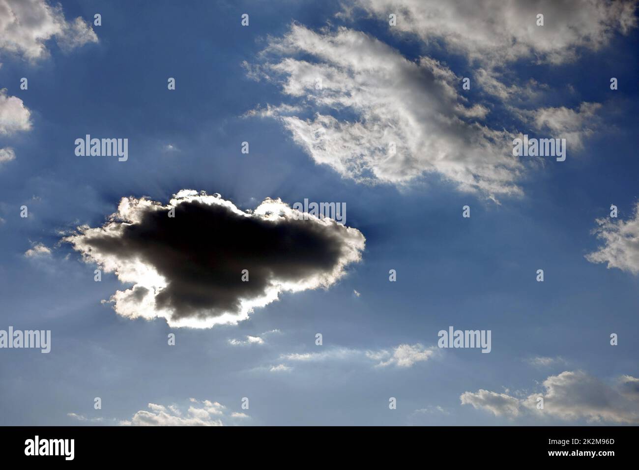 Schwarze Wolke bildet sich am blauen Himmel, dunkle Wolke bildet sich in verschiedenen und interessanten Formen Stockfoto