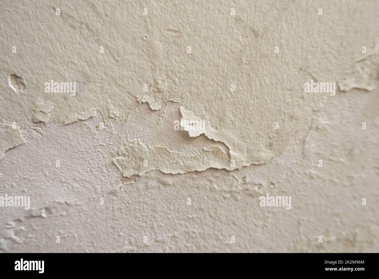 Wand, deren Farbe sich aufgrund von Wasser und Feuchtigkeit abgelöst hat Stockfoto