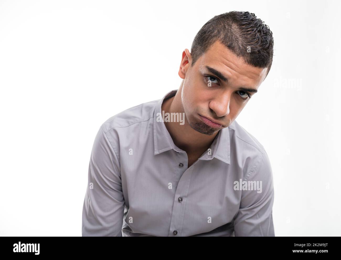 Junger enttäuschter Mann vor weißem Hintergrund Stockfoto