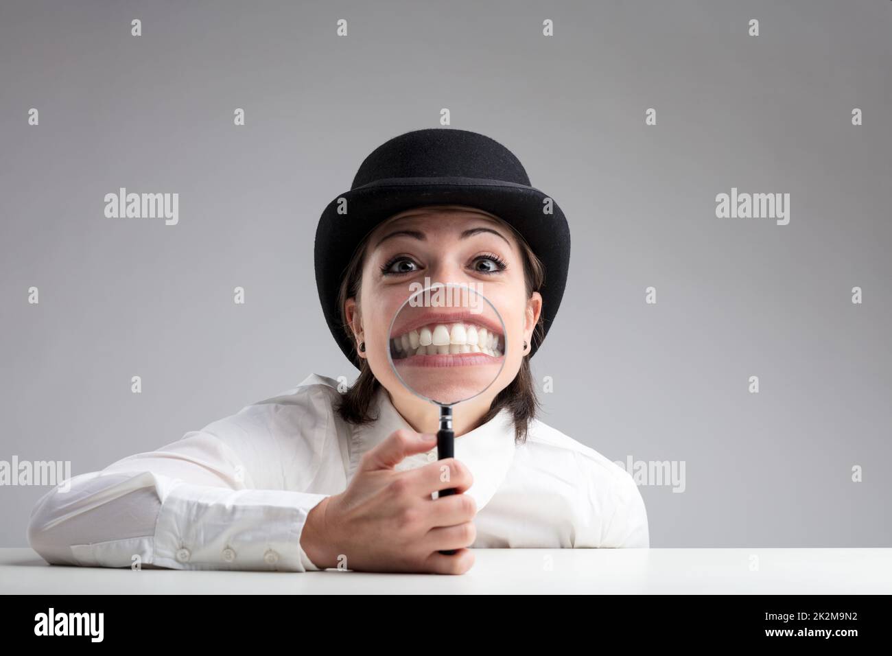 Zähne hinter einer Lupe und ein lustiges Gesicht Stockfoto