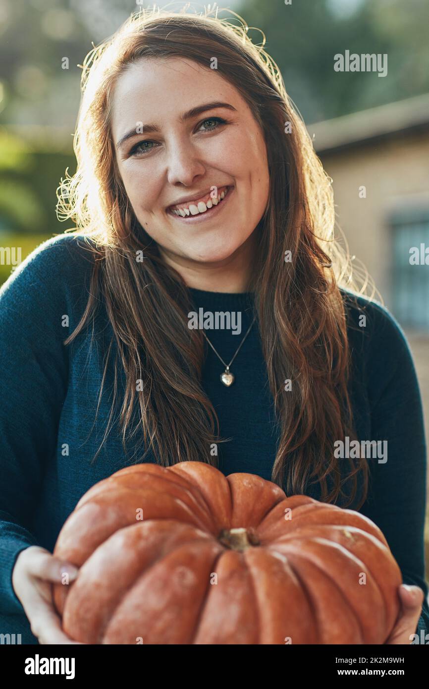 Mein Lieblingsurlaub kommt. Porträt einer jungen Frau, die einen Kürbis draußen hält. Stockfoto