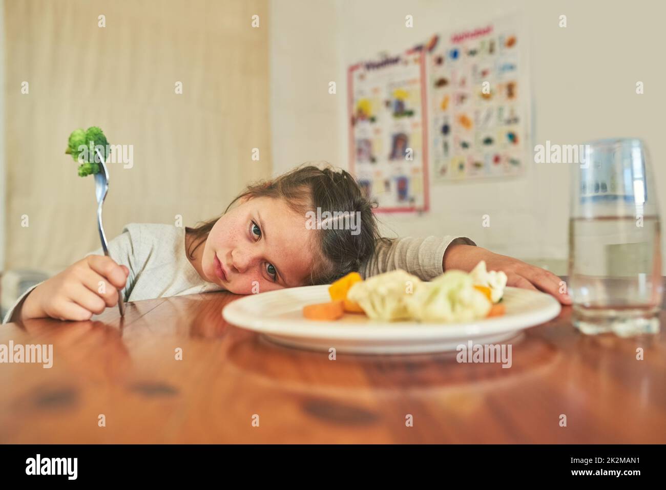 Ihr könnt mich nicht dazu bringen, dies zu essen. Aufnahme eines kleinen Mädchens, das sich weigert, ihren Brokkoli zu essen. Stockfoto