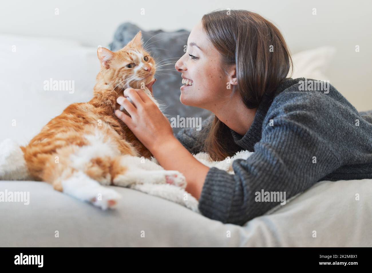 Du bist so eine purrfect Ergänzung zu meinem Leben. Aufnahme einer jungen Frau, die zu Hause ihre Katze streichelte. Stockfoto