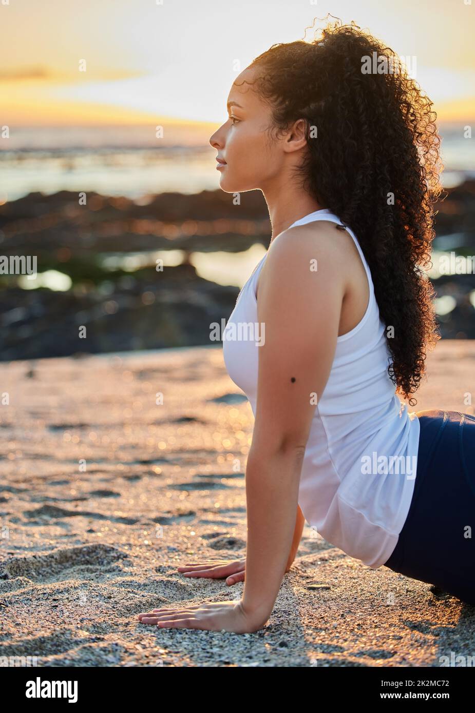 Der Strand ist der perfekte Ort für Yoga. Kurzer Screenshot einer attraktiven jungen Frau, die am Strand Yoga praktiziert. Stockfoto