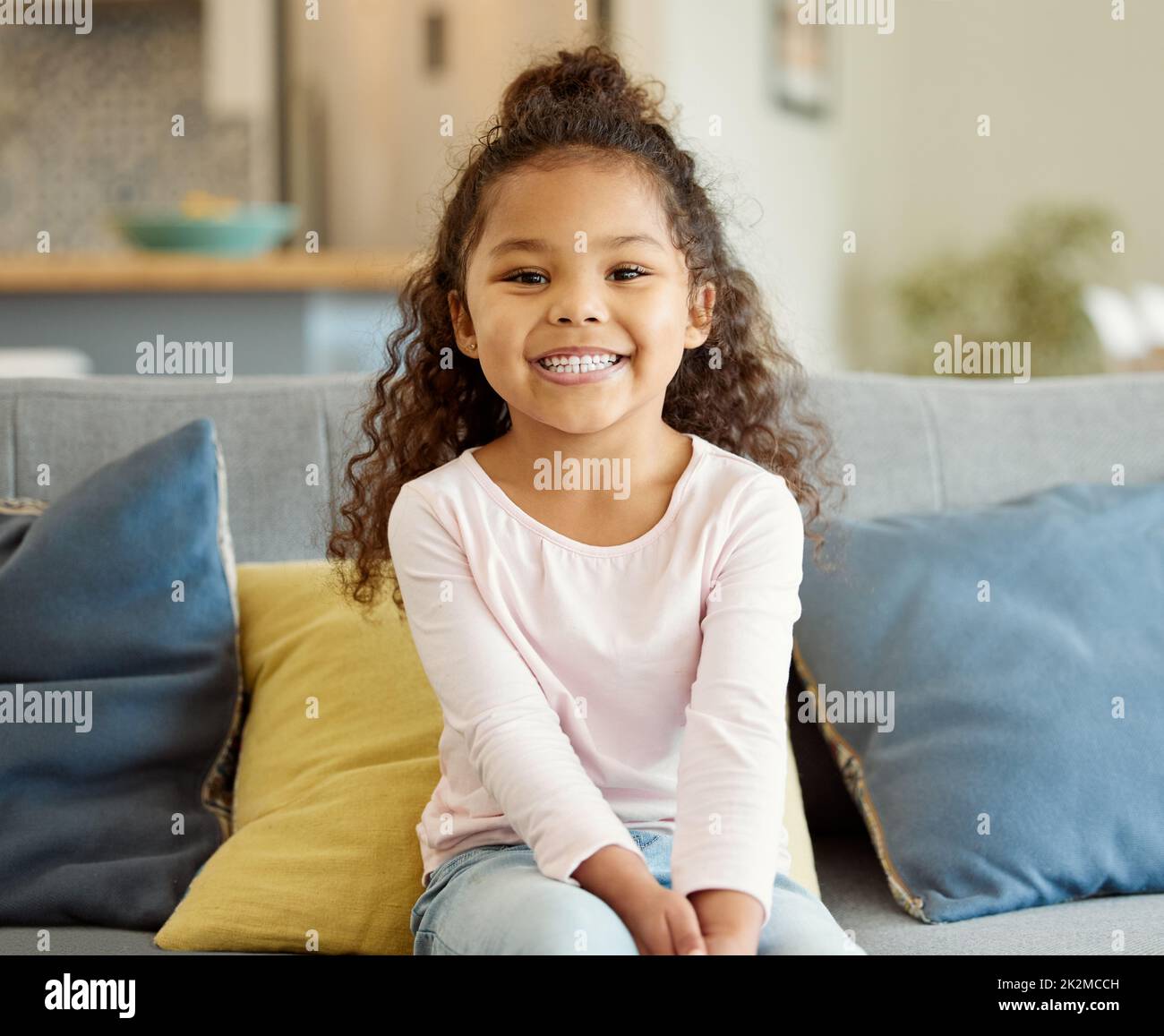 Mama versprach heute jede Menge Spaß. Porträt eines kleinen Mädchens, das zu Hause auf dem Sofa sitzt. Stockfoto