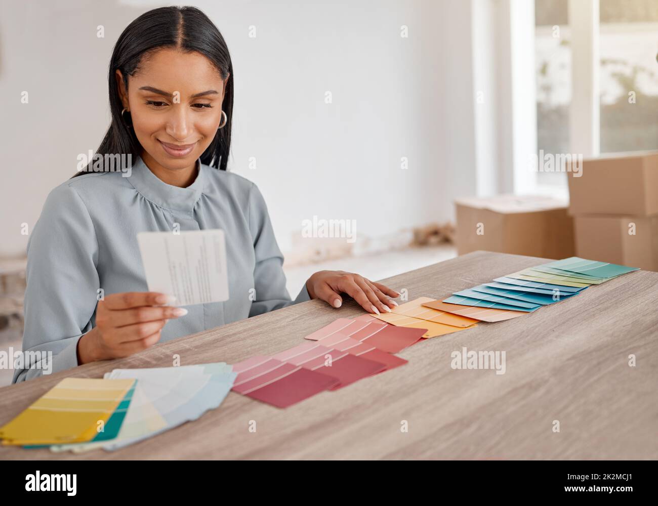 Das sieht aus wie der Gewinner. Aufnahme einer jungen Frau, die bei der Renovierung ihres Hauses verschiedene Farbfelder ansah. Stockfoto