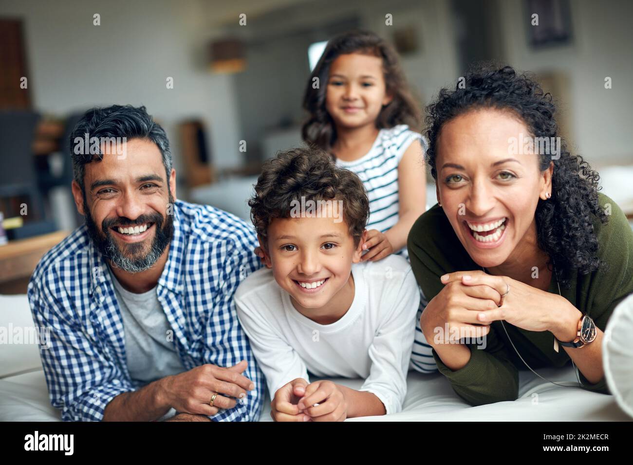 Quality Time stärkt ihre familiäre Bindung. Porträt einer glücklichen Familie, die sich zu Hause verbindet. Stockfoto