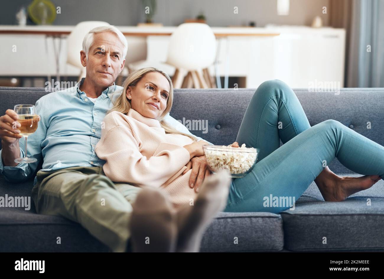 Die Bindung mit etwas Qualitätszeit ist uns wichtig. Kurze Aufnahme eines liebevollen, reifen Paares, das sich zu Hause auf dem Sofa entspannt. Stockfoto